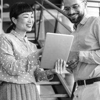 Two coworkers looking at a tablet device