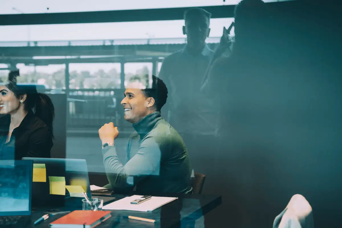 Two employees in a meeting in a glass-walled conference room