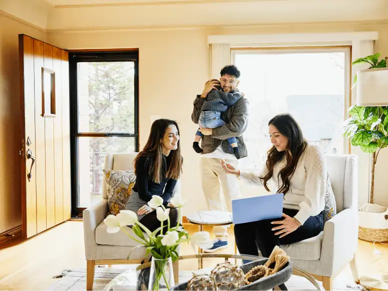 A family at home looks at a real estate agreement on a laptop