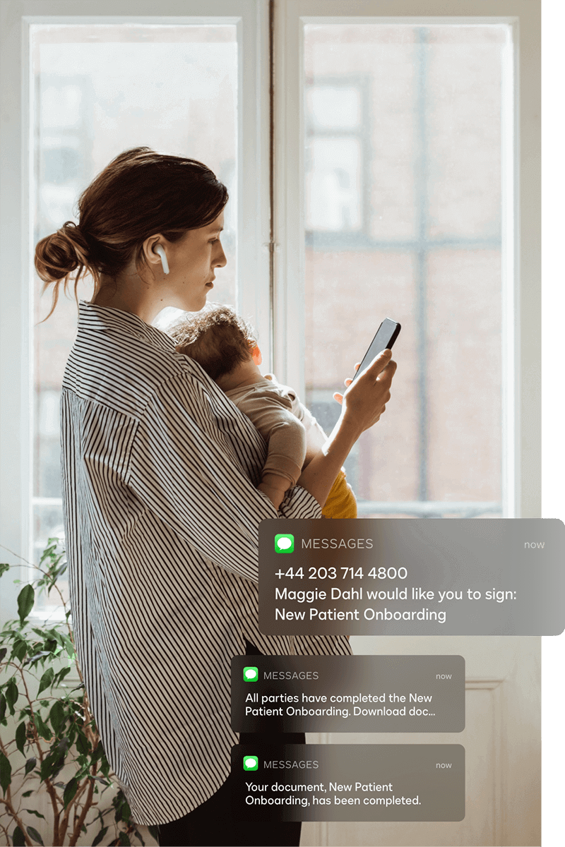 A woman holding a baby and looking at her phone sees mobile notifications for DocuSign eSignature