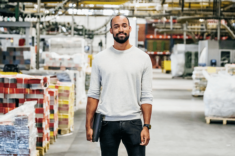 Person in a factory holding a laptop