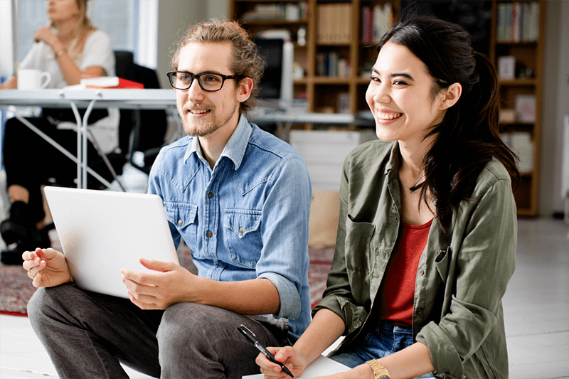 Two people in an office smiling